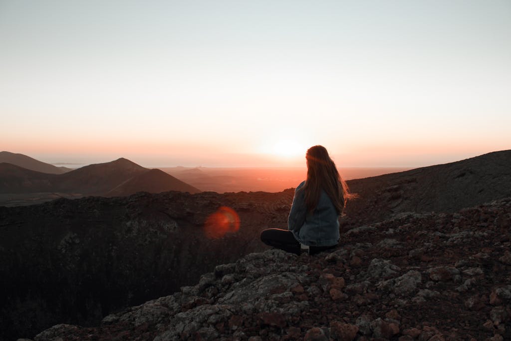 Woman Sitting on Mountain Top